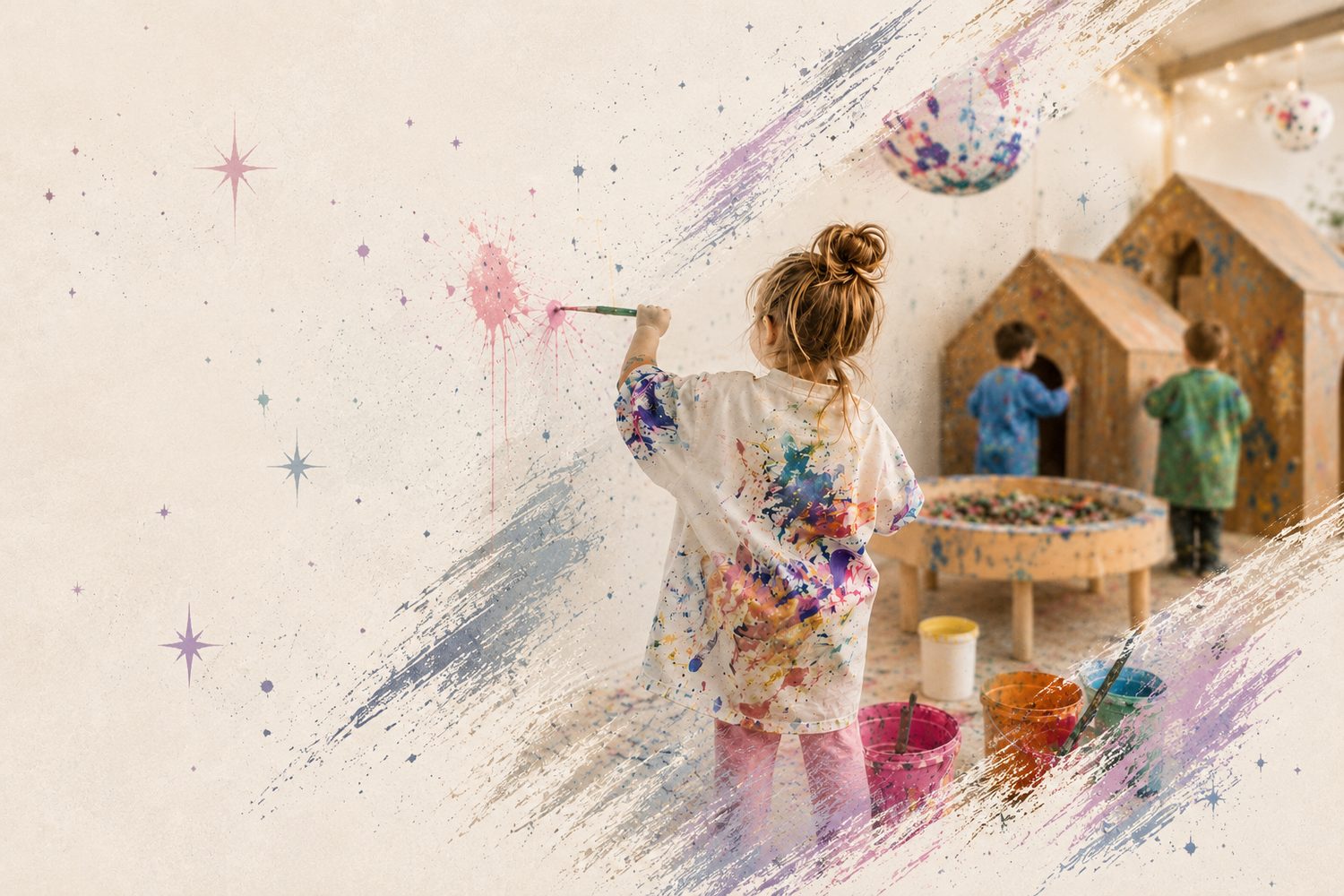 A child painting at a studio wall with cardboard play houses nearby